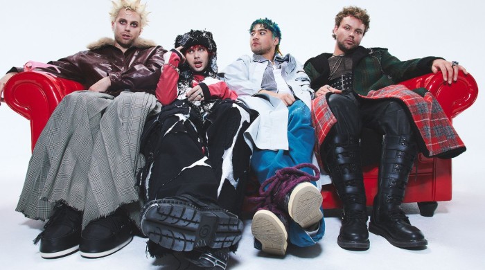 The band 5 seconds of summer sat on a red leather couch