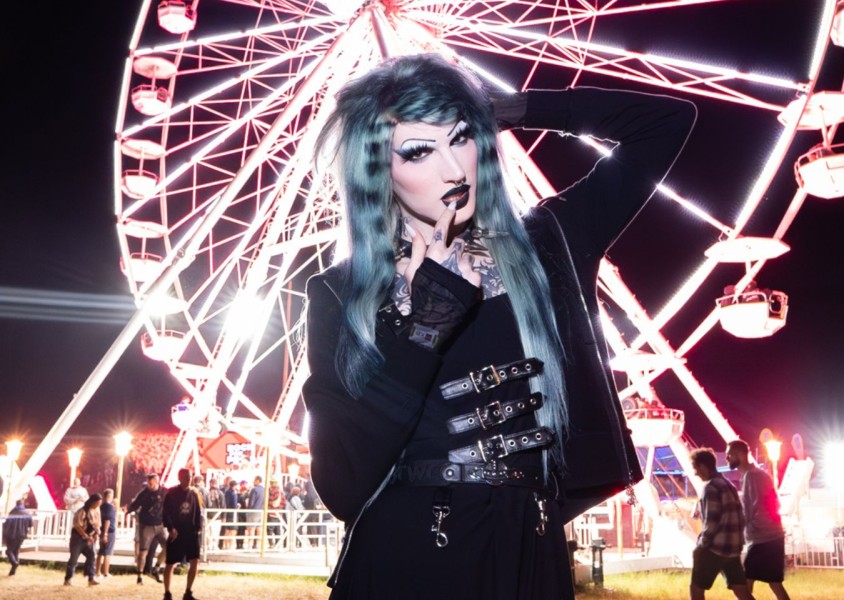 electronic artist 6arely humanposing in front of a light up ferris wheel at nightx