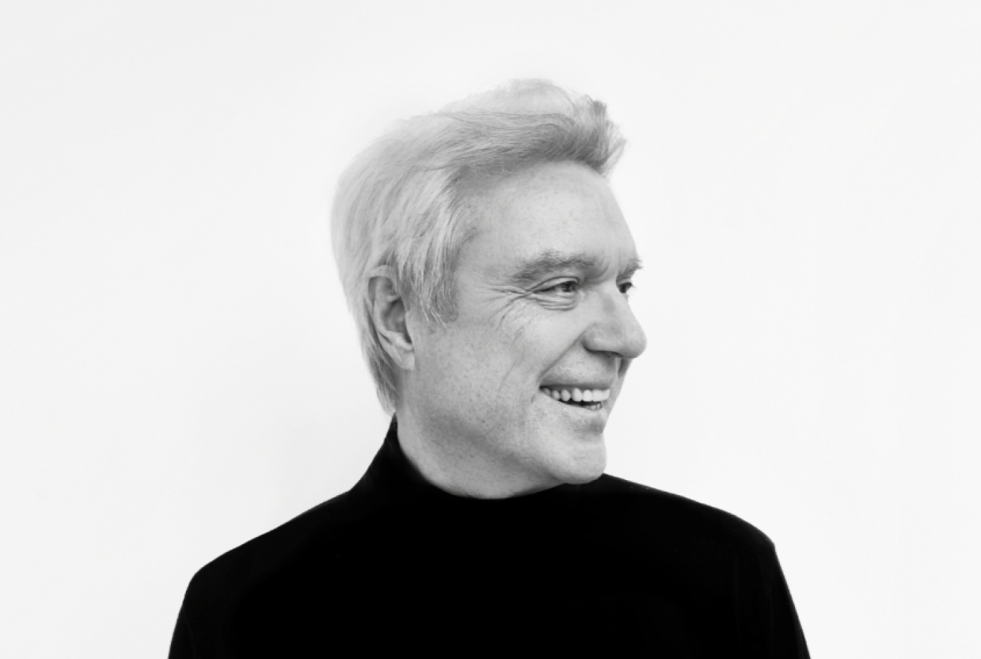David Byrne smiling and looking into the distance