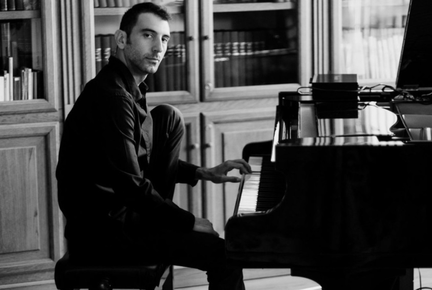 Andrea Vanzo looking at the camera while playing the piano.