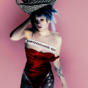 Artist Ashnikko wearing a hat and standing in front of a pink wall