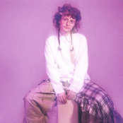 Artist Cavetown sitting against pink background