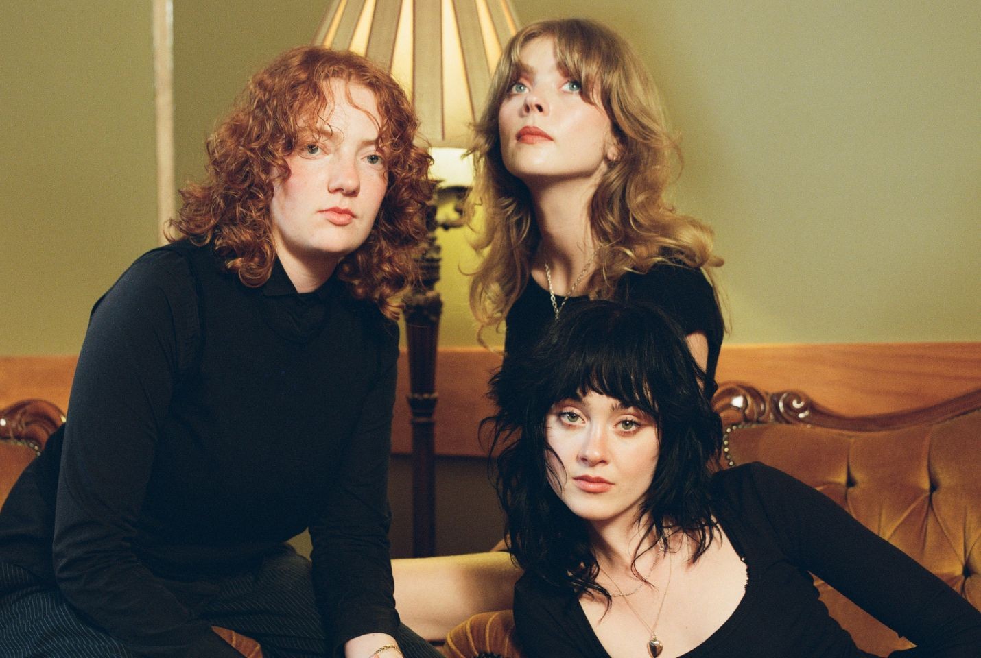 Three people sat together wearing black outfits
