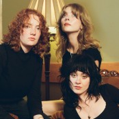 Three people sat together wearing black outfits