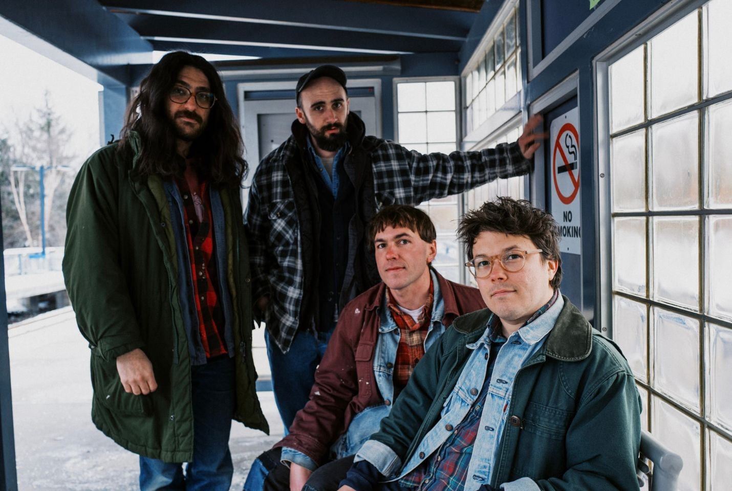 The band Friendship sat in a shelter at a train platform
