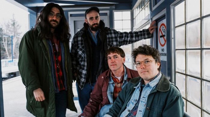 The band Friendship sat in a shelter at a train platform