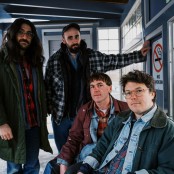 The band Friendship sat in a shelter at a train platform