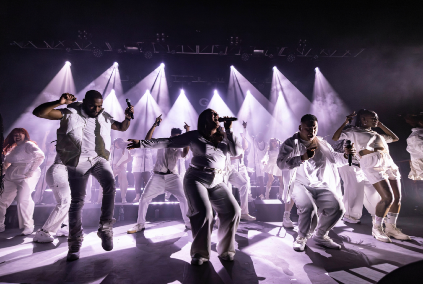 House Gospel Choir, dressed in all white and on stage performing.