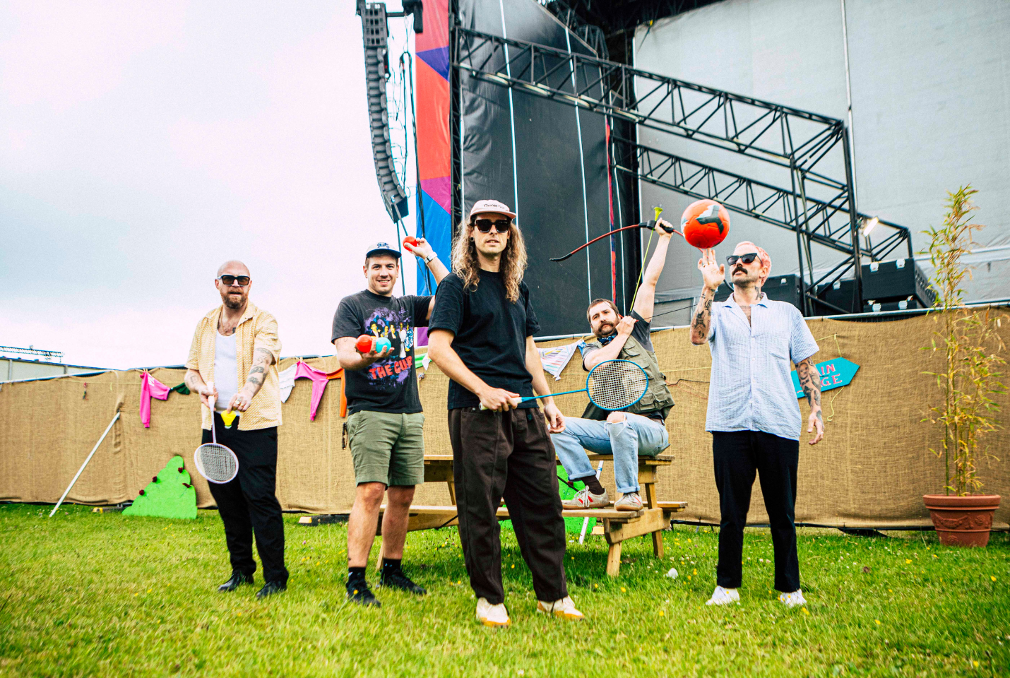 IDLES outside with badminton rackets and balls