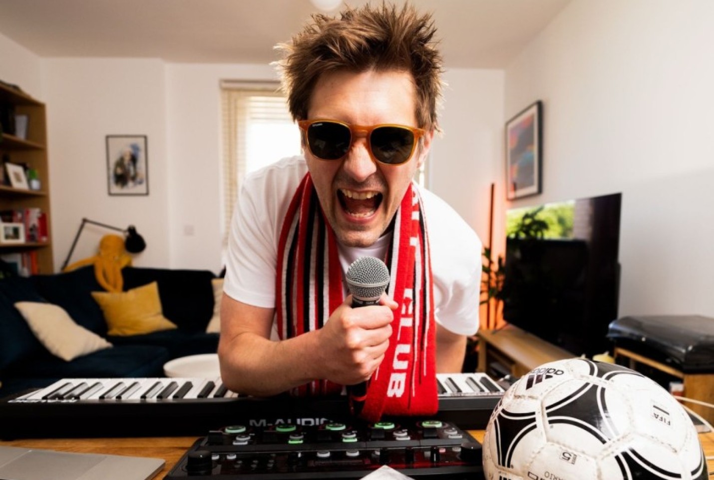 JJ Bull looking into the camera while shouting into a microphone.
