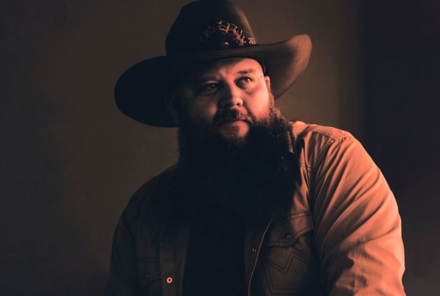 Larry Fleet wearing a cowboy hat and looking into the distance.