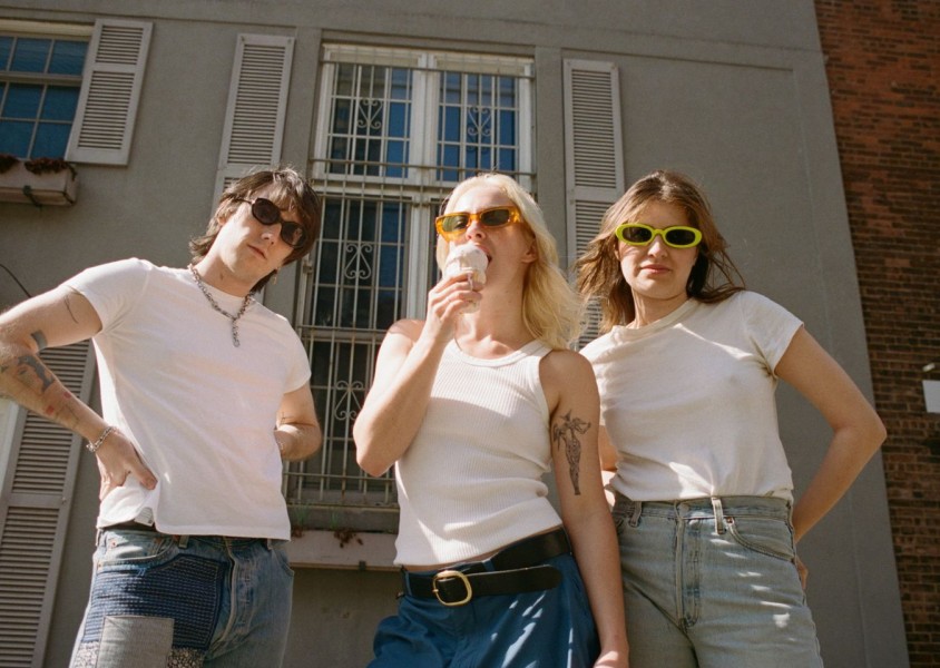 Three people in white tops, blue jeans, and sunglassesx