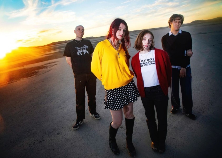 The band Momma standing in a beach looking into the camera.x