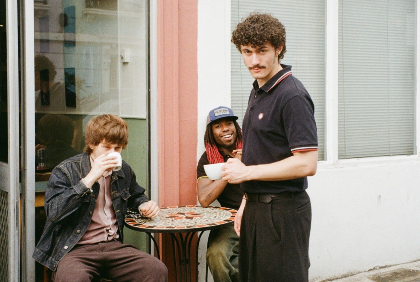 three men outside a coffee shop