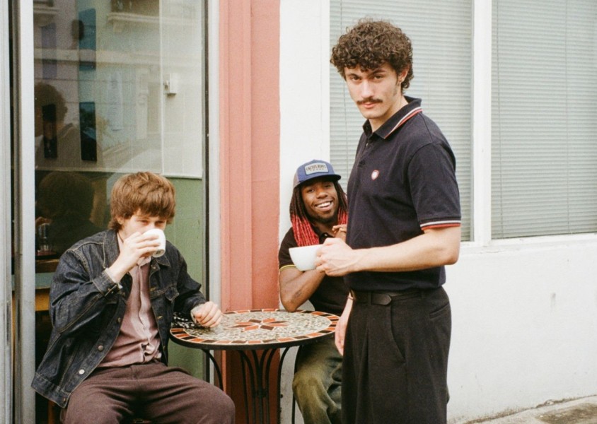 three men outside a coffee shopx