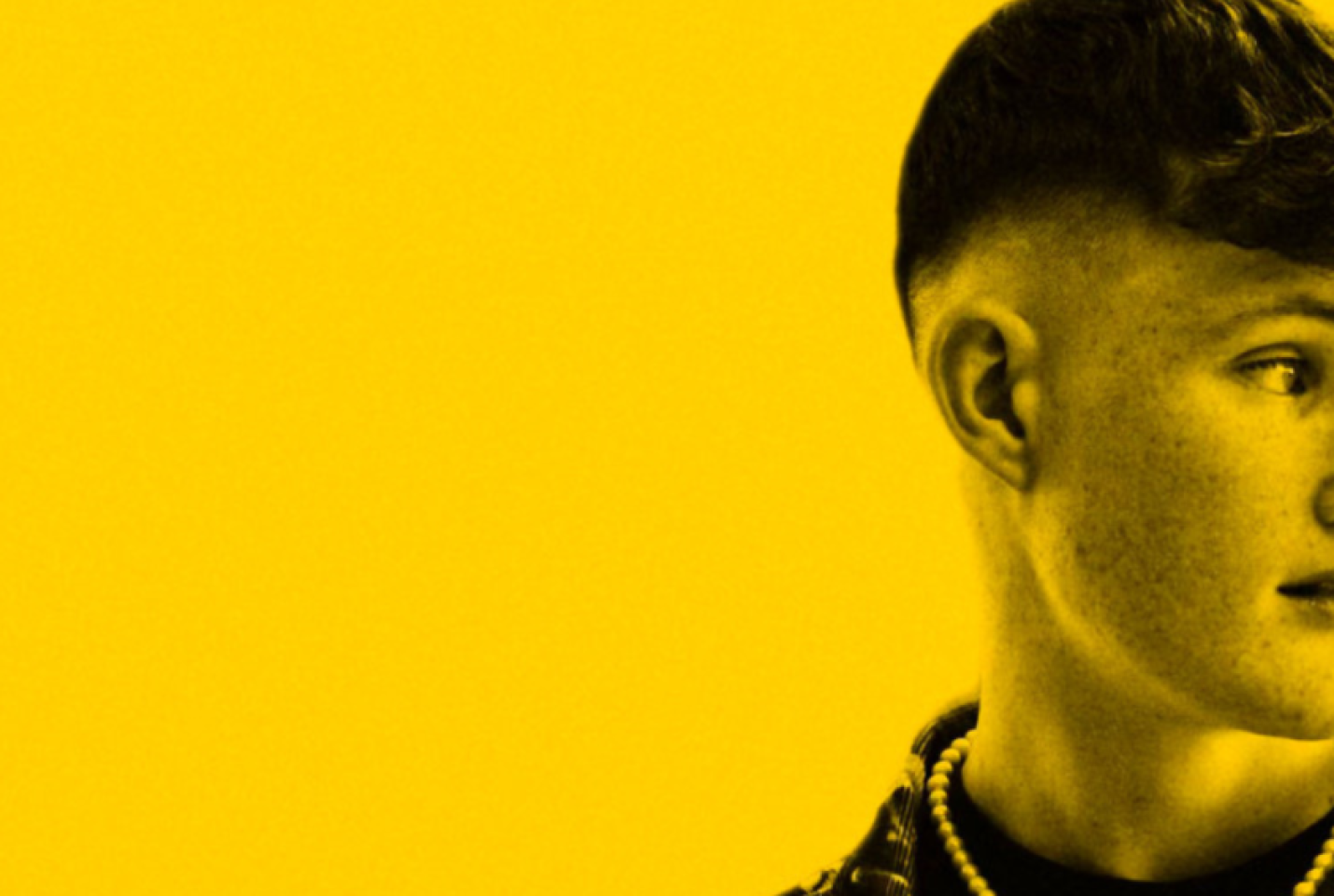 Half of Pat Hamilton's face looking into the distance on a bright yellow background.