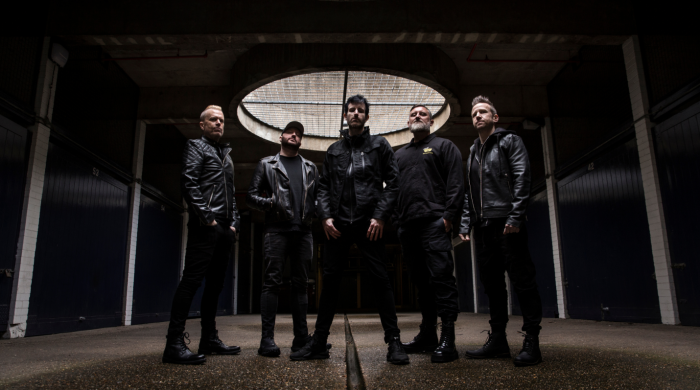 Five men standing in a dark room with dark clothing