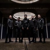 Five men standing in a dark room with dark clothing