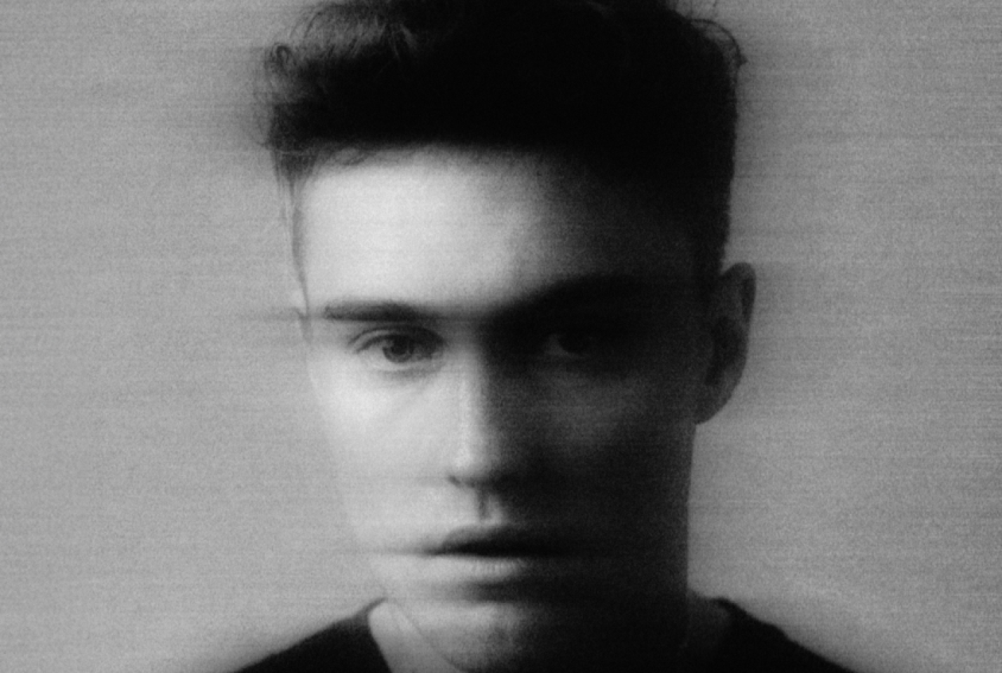 Sam Fender looking into the camera with part of his face blurred.