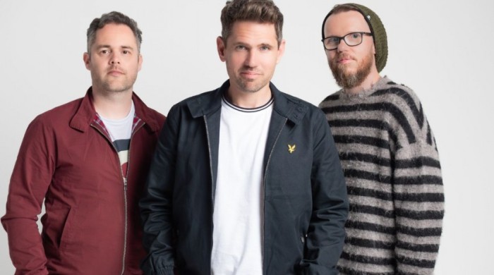 The members of Scouting for girls, Roy Stride, Greg Churchouse and James Rowlands looking at the camera smiling.