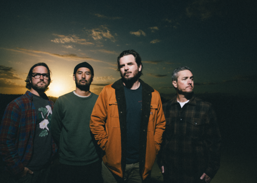 Artist thrice standing with sunset behind themx