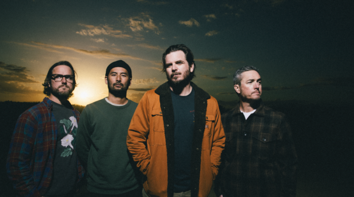 Artist thrice standing with sunset behind them