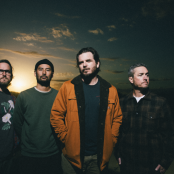 Artist thrice standing with sunset behind them