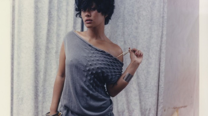 A woman with short dark hair wearing a grey knitted dress