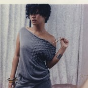 A woman with short dark hair wearing a grey knitted dress