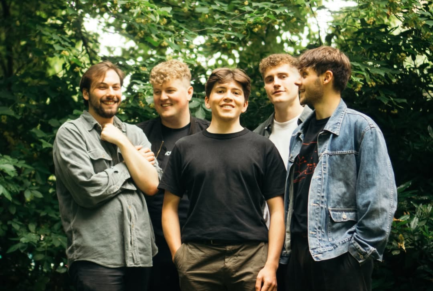Members of the band 'Waverly' standing outside in a forest
