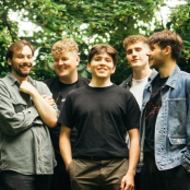 Members of the band 'Waverly' standing outside in a forest