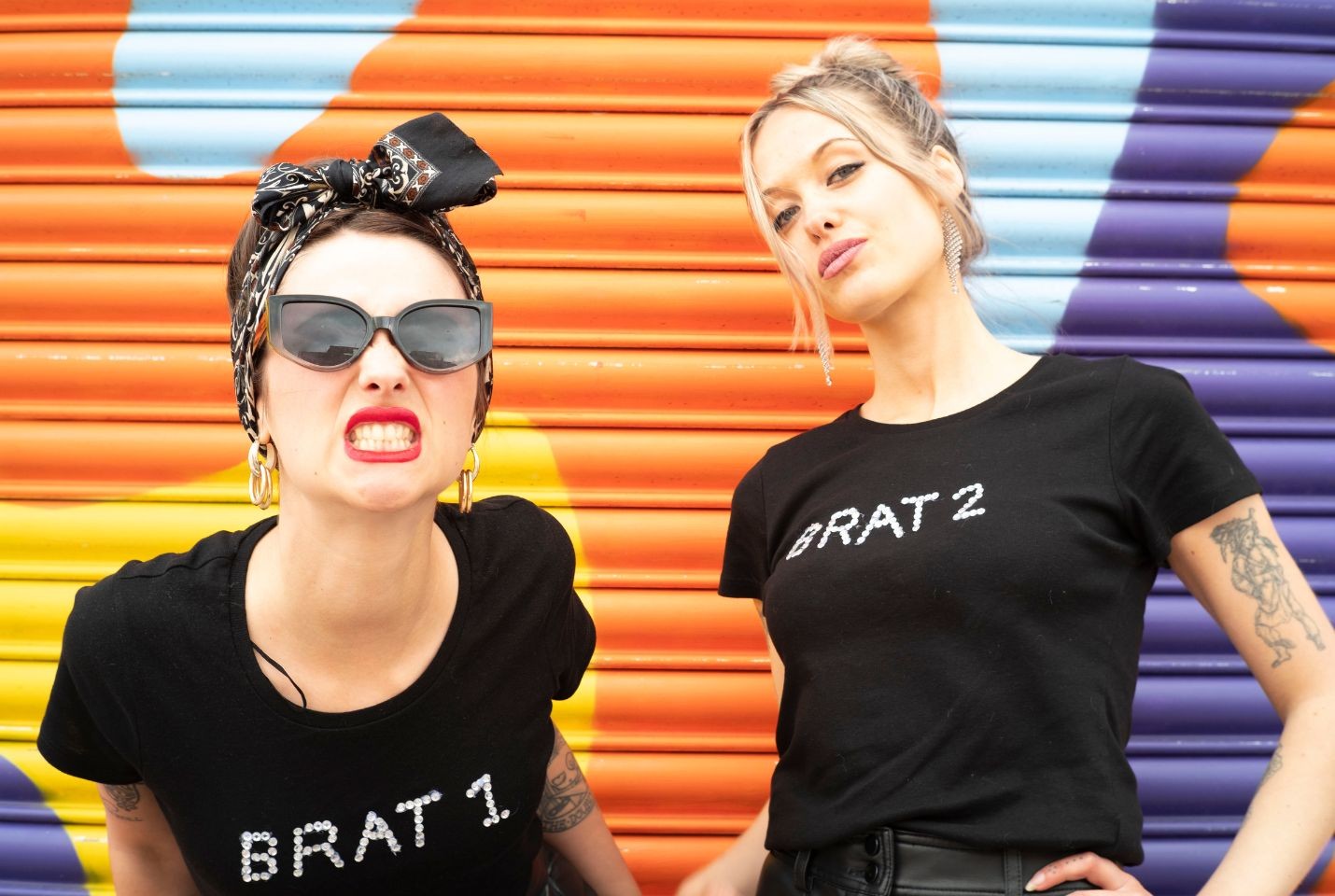 two woman stood in front of a colourful door