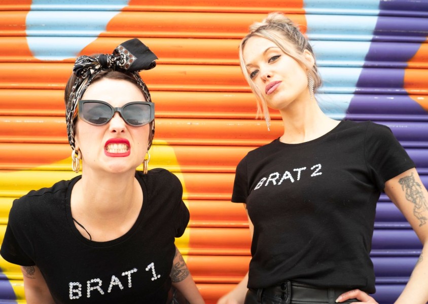 two woman stood in front of a colourful doorx