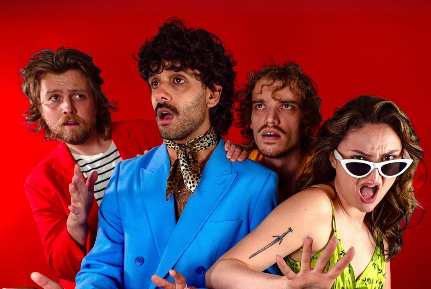 Four people stood in front of a red back drop