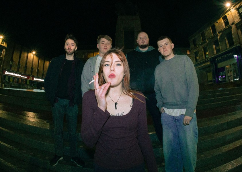 4 men standing on steps with woman smoking cigarettex