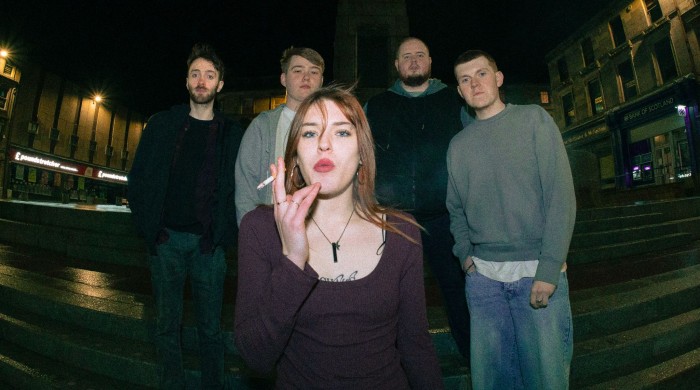 4 men standing on steps with woman smoking cigarette